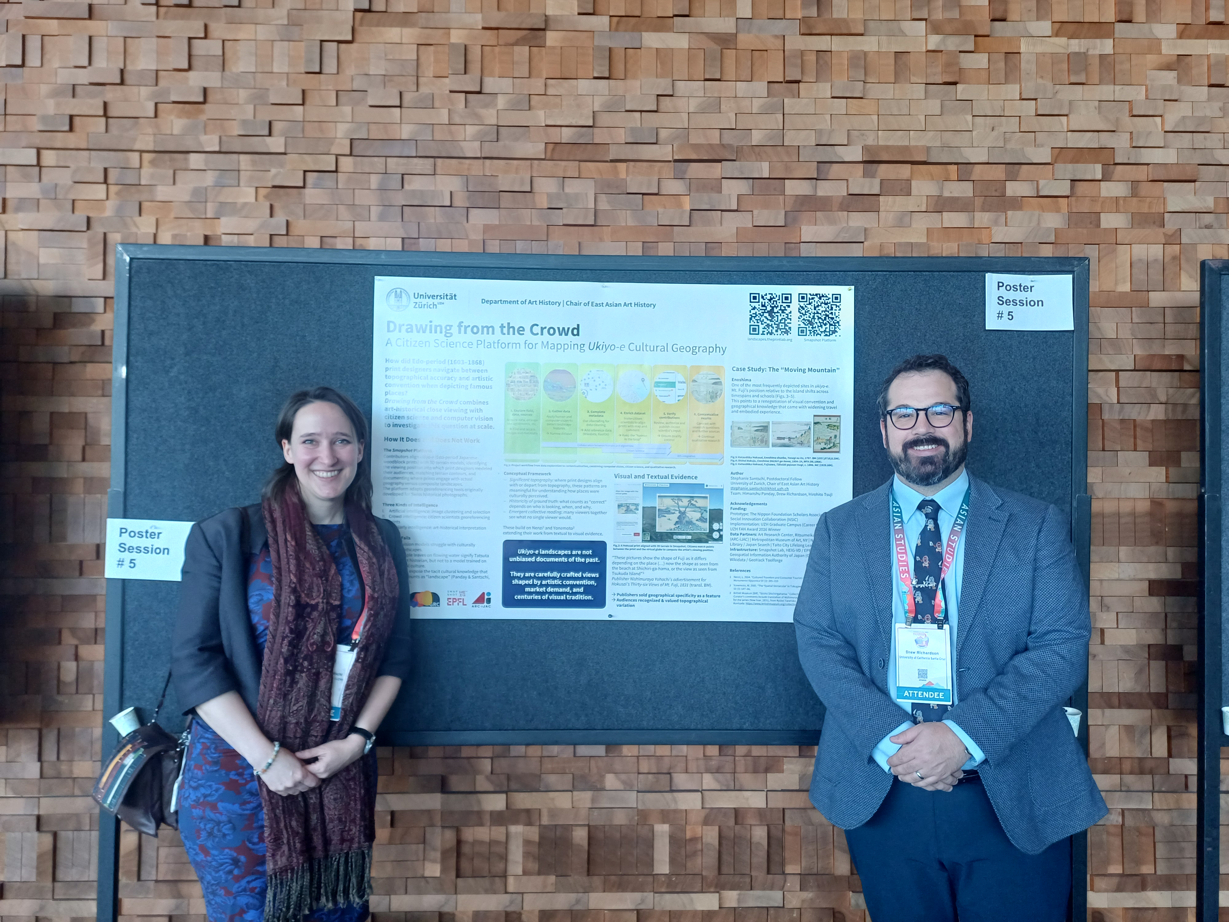 Stephanie Santschi and Drew Richardson at AAS 2026 in Vancouver, standing in front of the Drawing from the Crowd poster